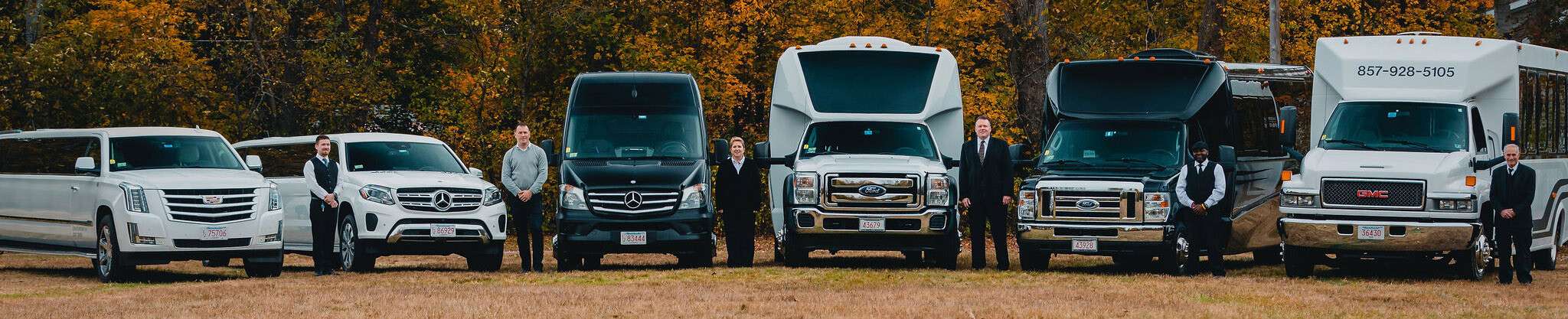 Chauffeurs in suits standing beside a lineup of limousines, vans and party buses