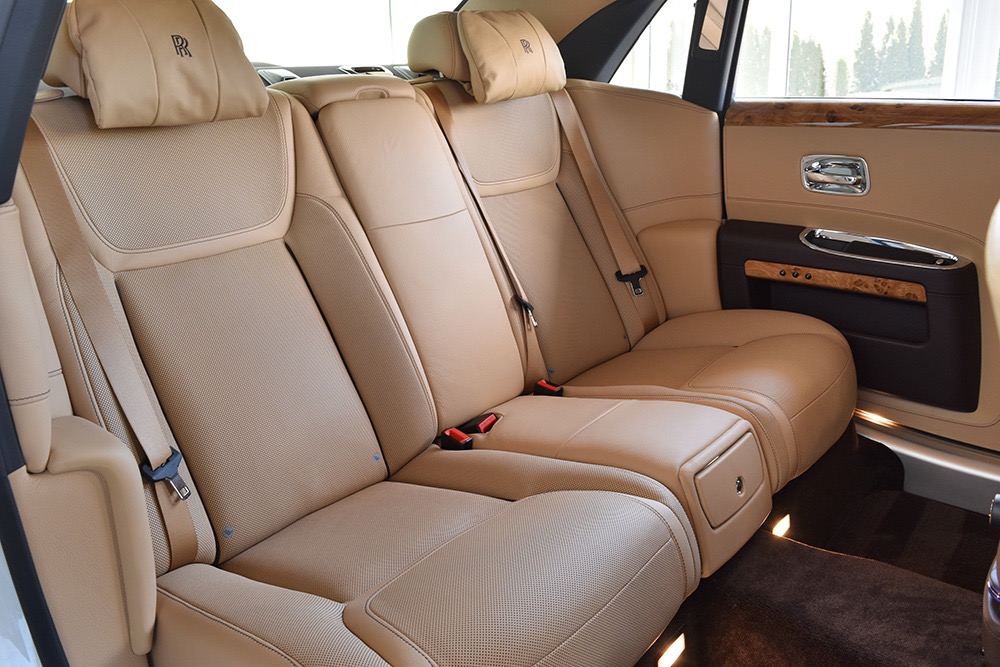 Rolls-Royce rear seats in beige leather with RR monogram headrests and wood door trim