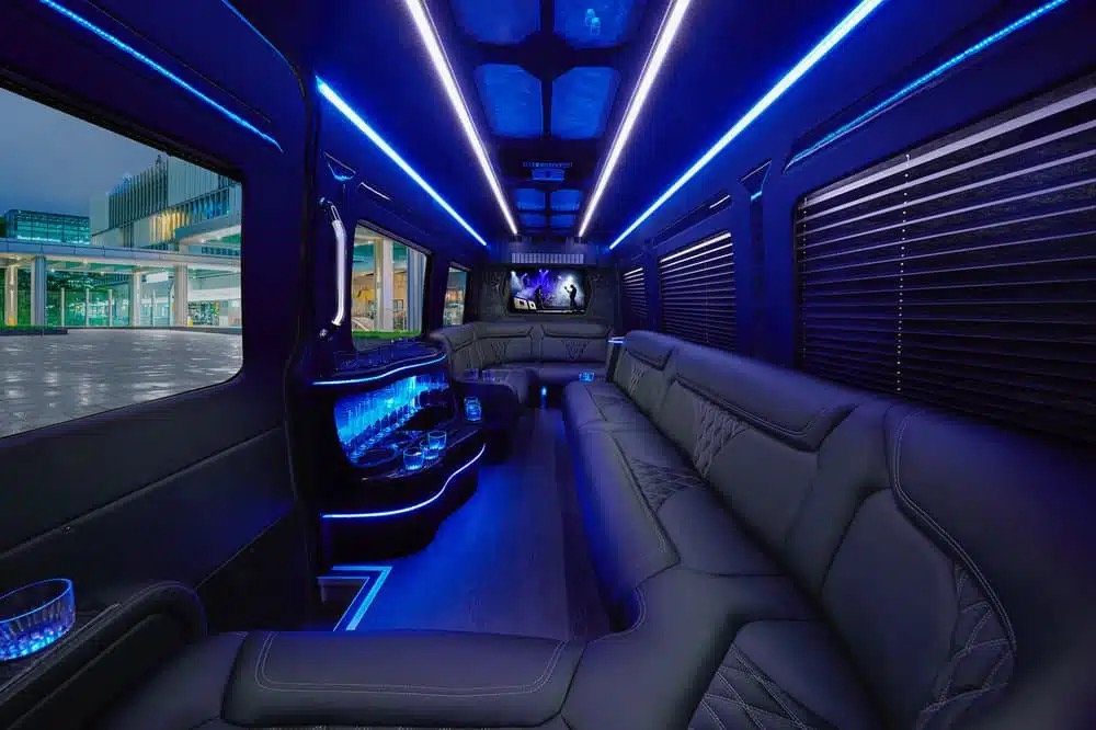 Limo van interior with blue LED lights, black leather seats, a bar and TV