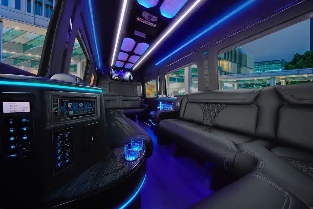 Limo van interior with black leather seats, blue LED lights, TV and cup holders