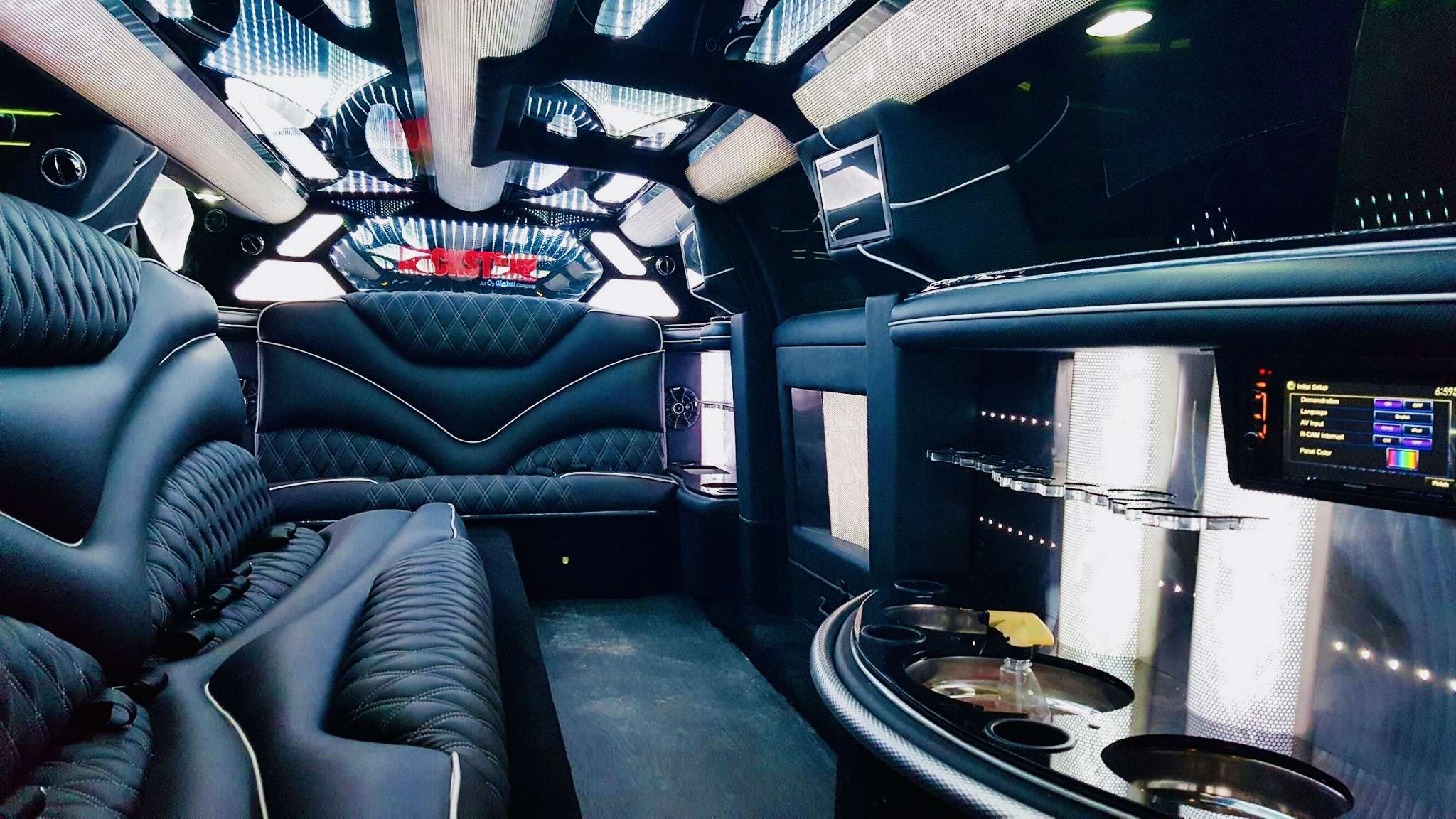 Limousine interior with quilted black leather seats, LED ceiling lights and a bar