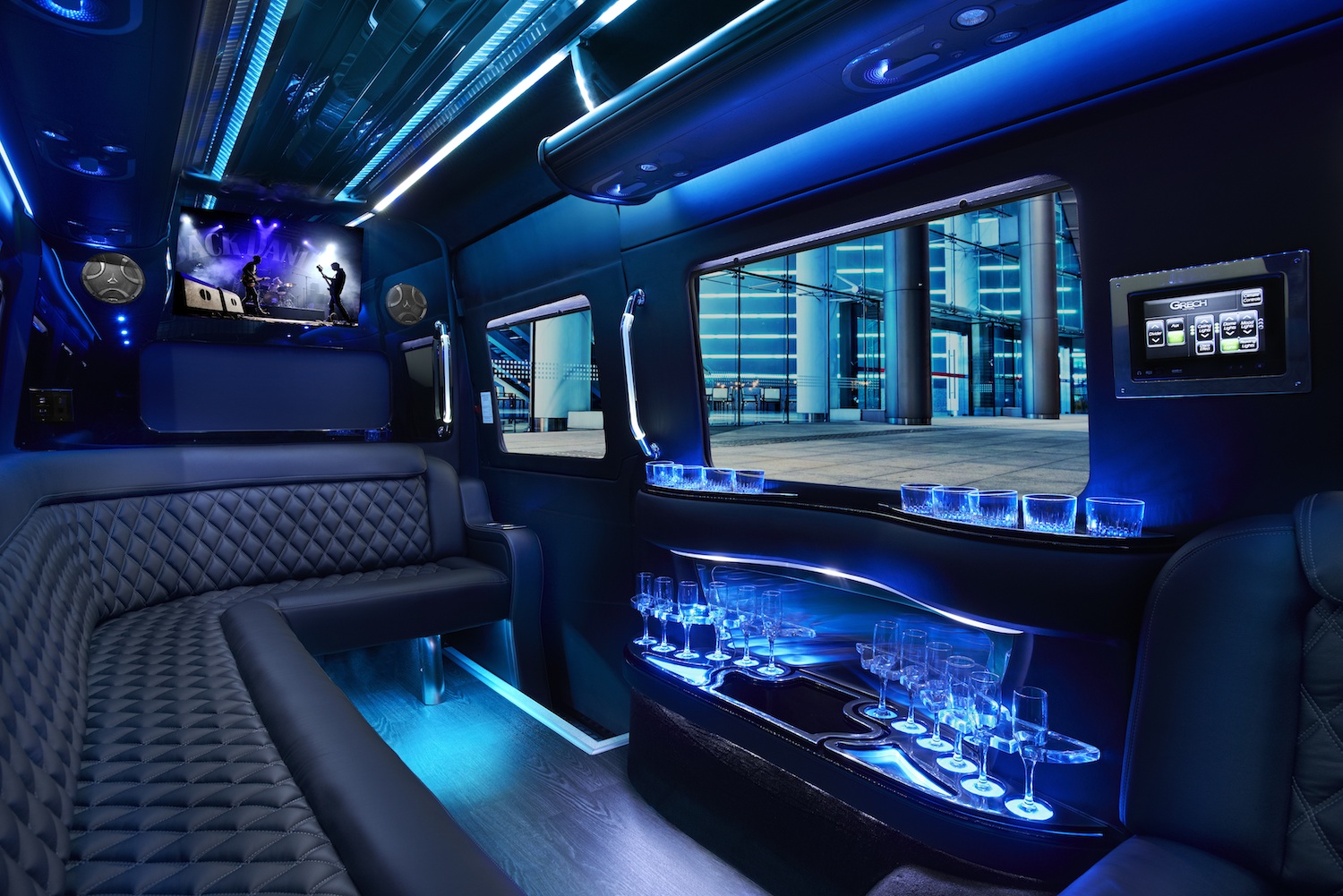 Limo van interior with quilted leather seats, blue LED lights, glassware bar and TV