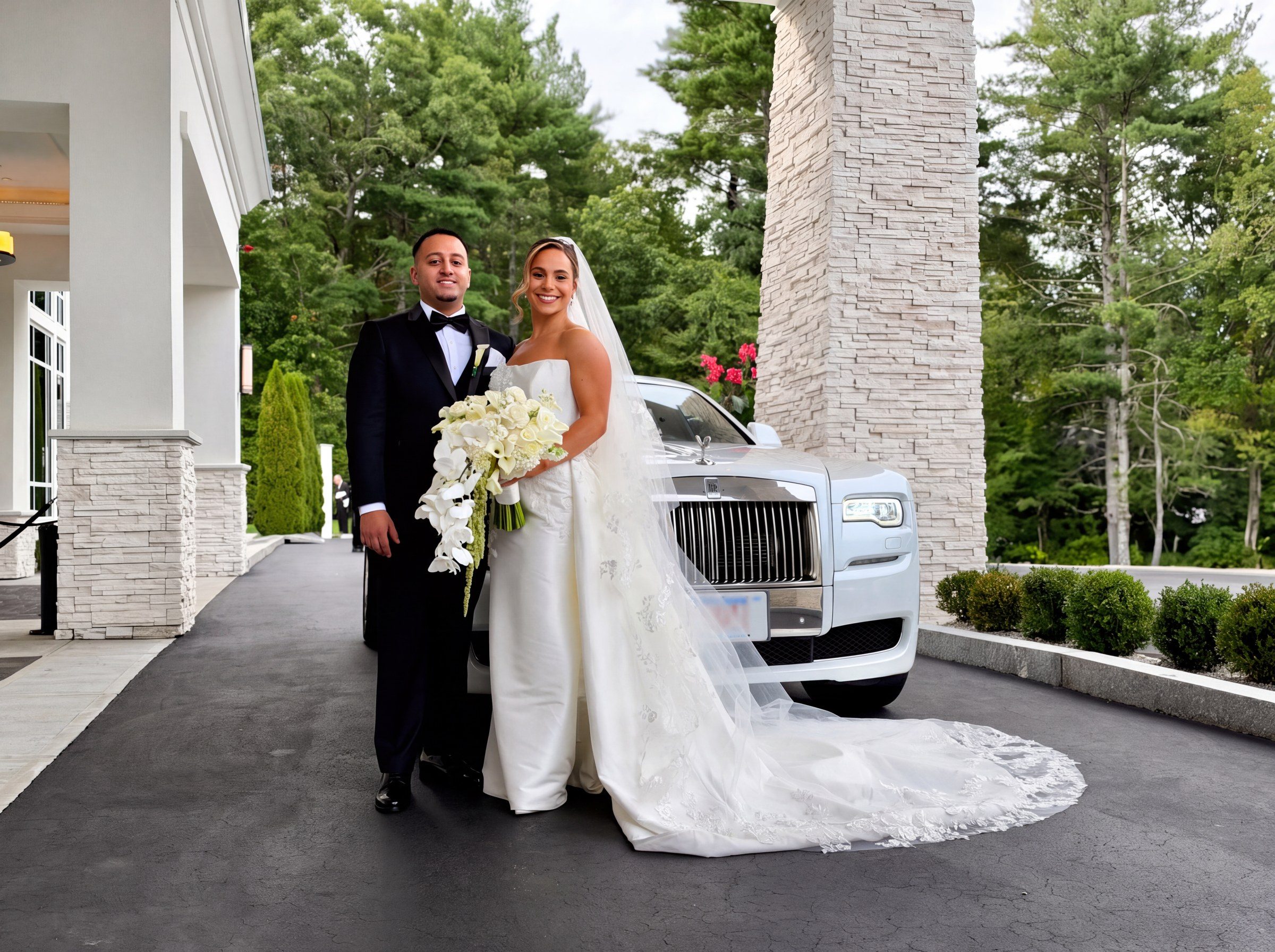 Bride and groom in front of a white Rolls-Royce Ghost at a wedding venue